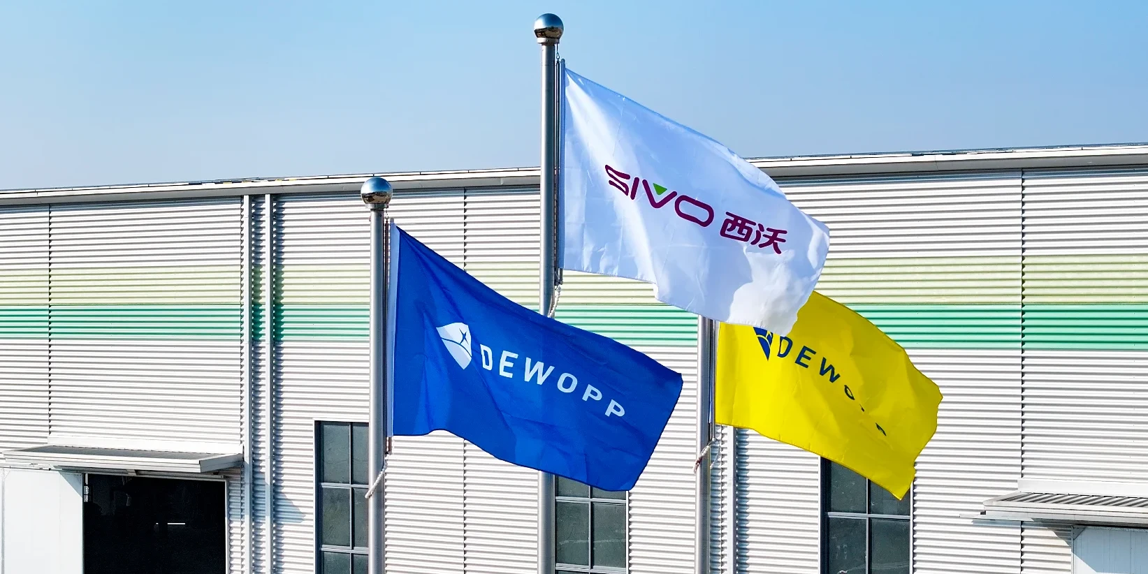 DEWOPP and SIVO corporate flags at the factory — strong governance
